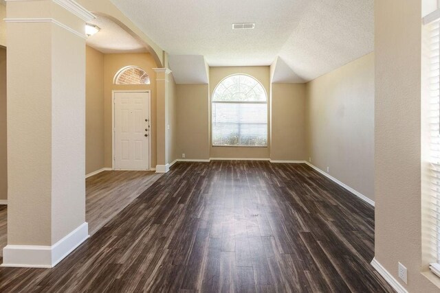 entrance foyer with visible vents, arched walkways, baseboards, and dark wood-style floors