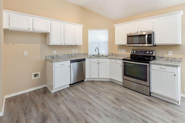 kitchen featuring white cabinetry, appliances with stainless steel finishes, a sink, and light wood finished floors