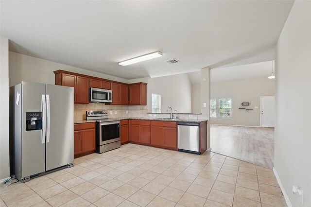 kitchen featuring backsplash, visible vents, a sink, stainless steel appliances, and light tile patterned flooring