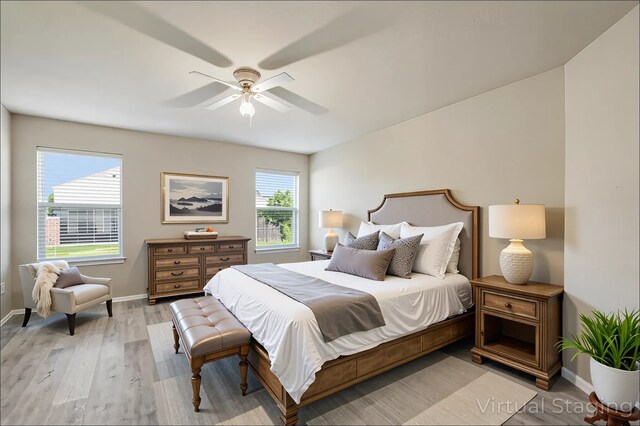 bedroom featuring baseboards, a ceiling fan, and light wood-style floors