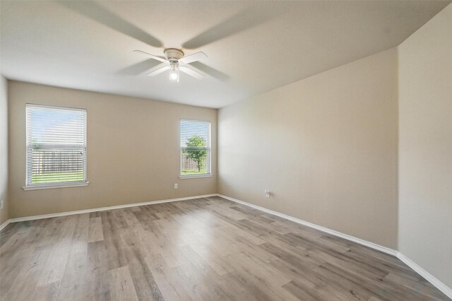 empty room featuring baseboards, ceiling fan, and wood finished floors