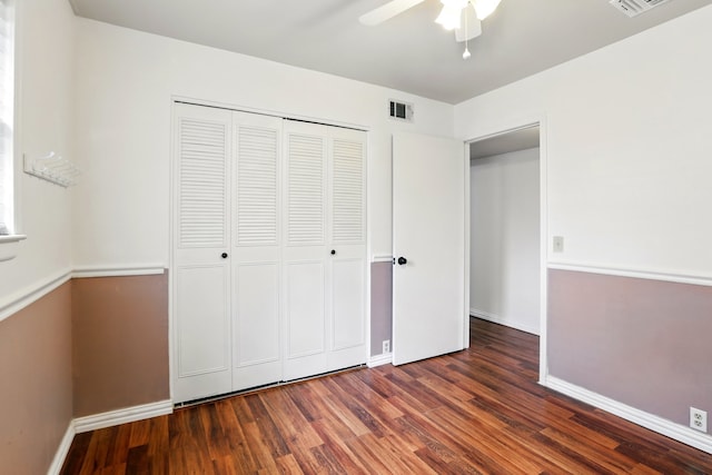 unfurnished bedroom featuring baseboards, visible vents, wood finished floors, and a closet