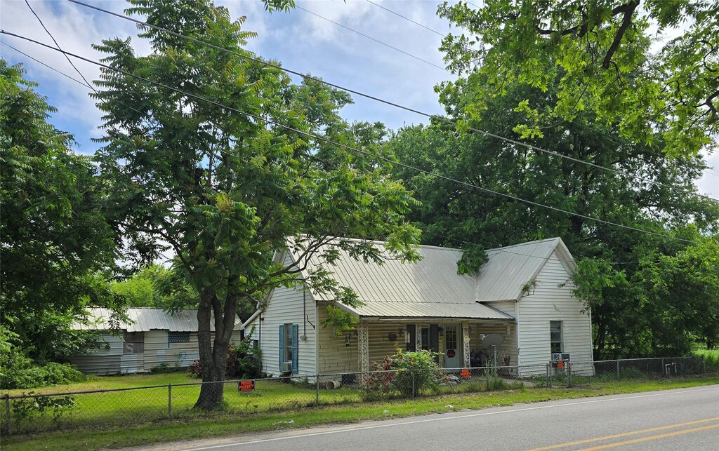view of front of house featuring a porch, a fenced front yard, and metal roof