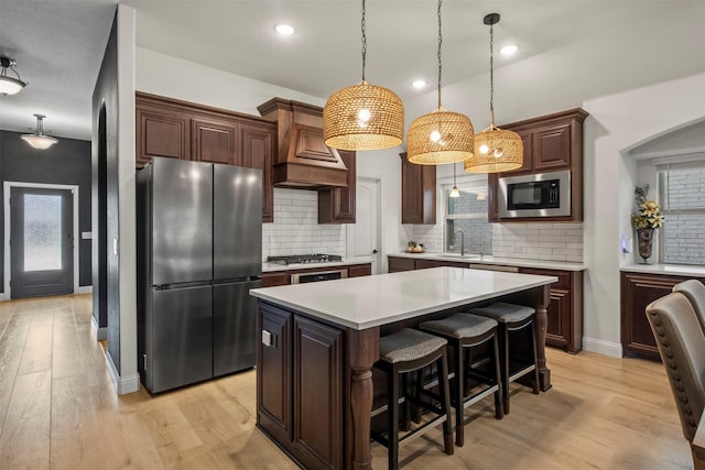 1248 Starlight Ave, Aubrey, TX 76227 - kitchen with stainless steel appliances, a sink, light countertops, arched walkways, and light wood-type flooring