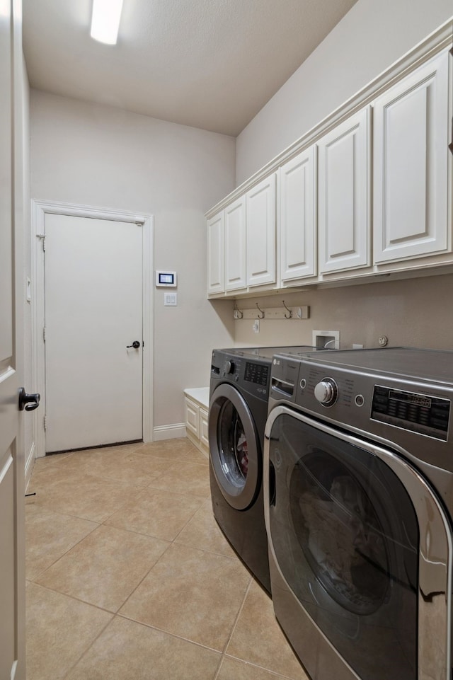 2206 Glasgow Dr, Trophy Club, TX 76262 - laundry area with cabinet space, washing machine and clothes dryer, baseboards, and light tile patterned floors