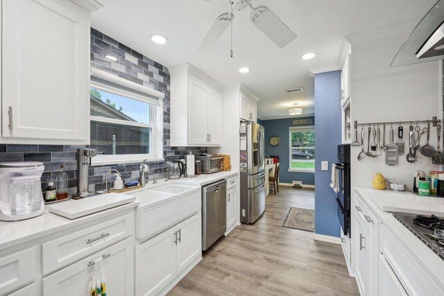 kitchen featuring ceiling fan, white cabinetry, a sink, appliances with stainless steel finishes, and backsplash