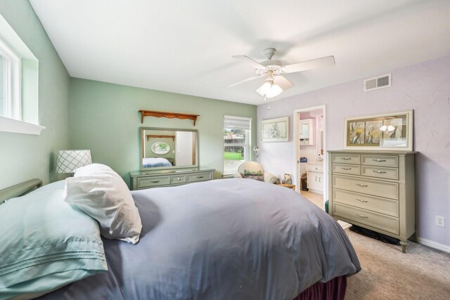 carpeted bedroom with connected bathroom, ceiling fan, visible vents, and baseboards