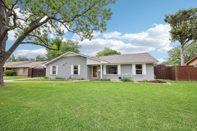 ranch-style house with fence, a front lawn, roof with shingles, and stucco siding