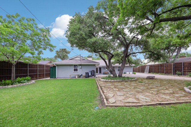 back of property featuring stucco siding, a fenced backyard, a patio area, a yard, and driveway