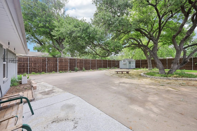 view of patio / terrace featuring a storage unit, a fenced backyard, and an outdoor structure