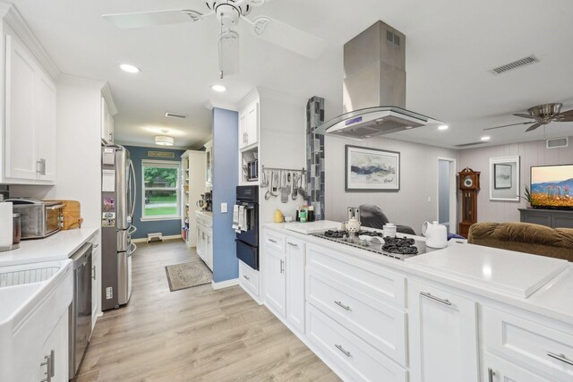 kitchen featuring ceiling fan, visible vents, island range hood, appliances with stainless steel finishes, and open floor plan