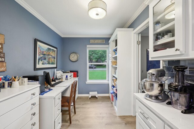 office space with light wood-type flooring, ornamental molding, and baseboards