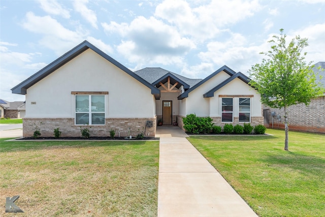view of front of house featuring stucco siding, a front lawn, and brick siding