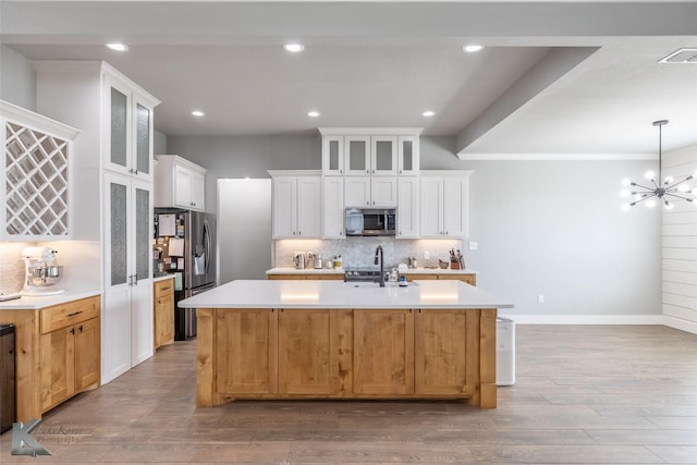 kitchen featuring visible vents, appliances with stainless steel finishes, tasteful backsplash, wood finished floors, and light countertops