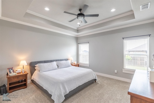 bedroom with crown molding, a raised ceiling, and visible vents