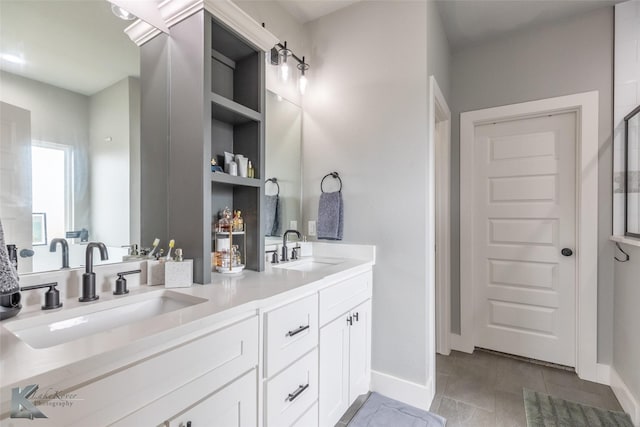 bathroom with baseboards, a sink, and double vanity