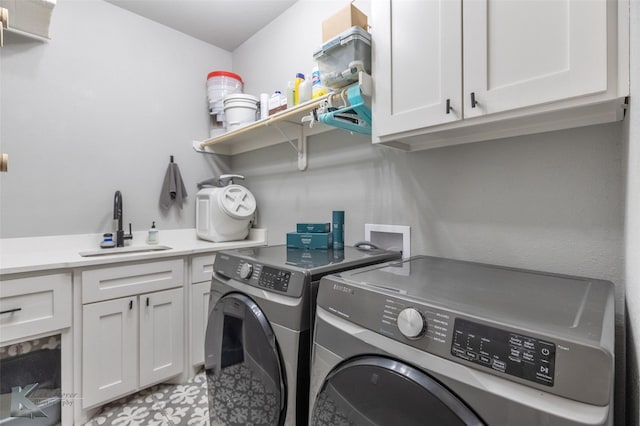washroom with independent washer and dryer, a sink, and cabinet space