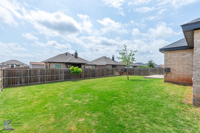 view of yard with a fenced backyard and a residential view