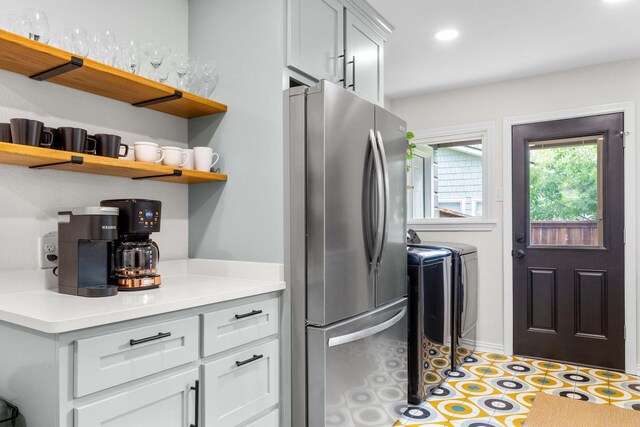 kitchen featuring open shelves, light countertops, freestanding refrigerator, recessed lighting, and washer and clothes dryer