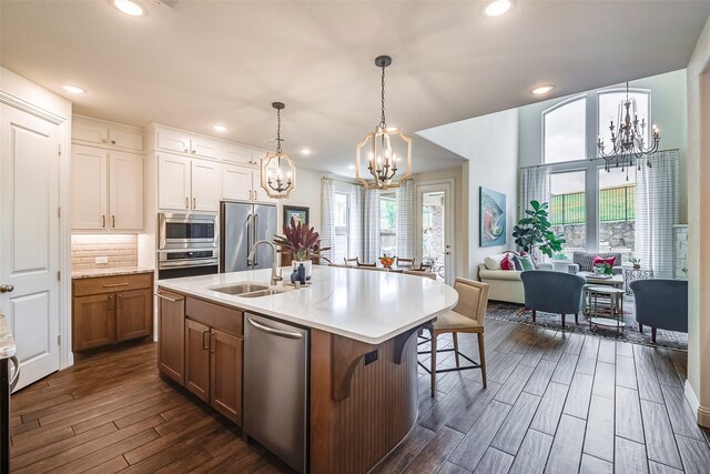 13845 Marys Ridge Rd, Fort Worth, TX 76008 - kitchen featuring appliances with stainless steel finishes, dark wood finished floors, a sink, light countertops, and an inviting chandelier