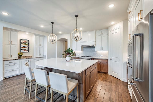 13845 Marys Ridge Rd, Fort Worth, TX 76008 - kitchen featuring a breakfast bar area, dark wood-style flooring, appliances with stainless steel finishes, a chandelier, and an island with sink