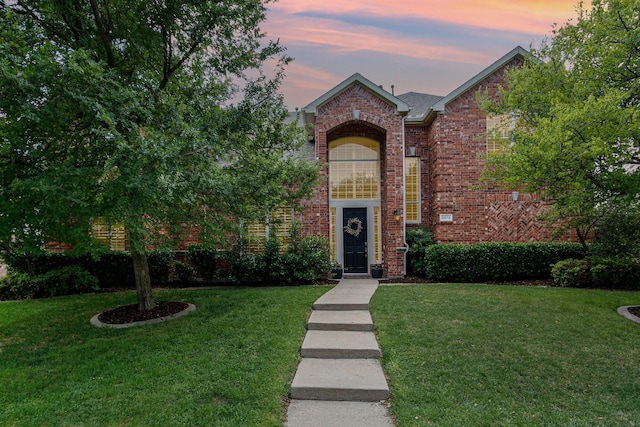 view of front of house featuring a front lawn and brick siding