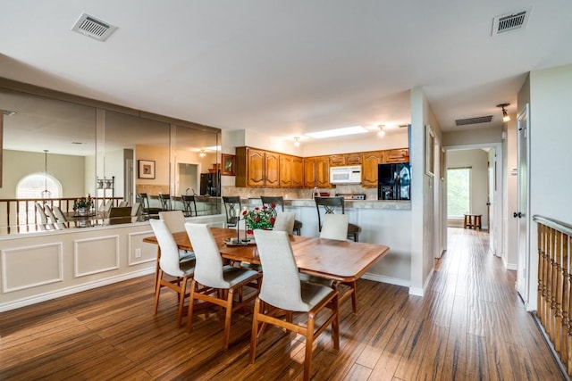dining room featuring visible vents and dark wood-style floors