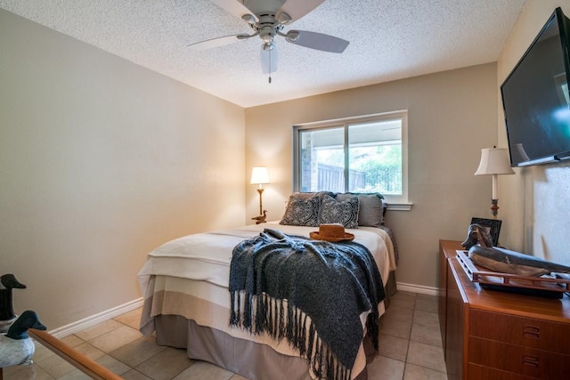 bedroom featuring baseboards, a textured ceiling, ceiling fan, and light tile patterned floors