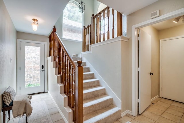 entrance foyer featuring stairs and light tile patterned floors