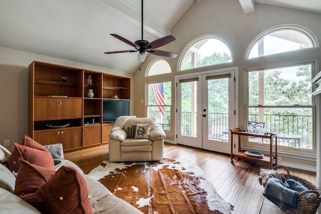 living area featuring a ceiling fan, french doors, high vaulted ceiling, beamed ceiling, and light wood-style floors