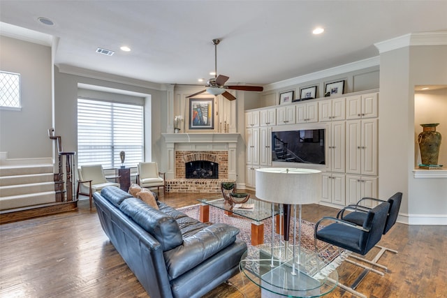 living room featuring a brick fireplace, visible vents, a wealth of natural light, and stairs