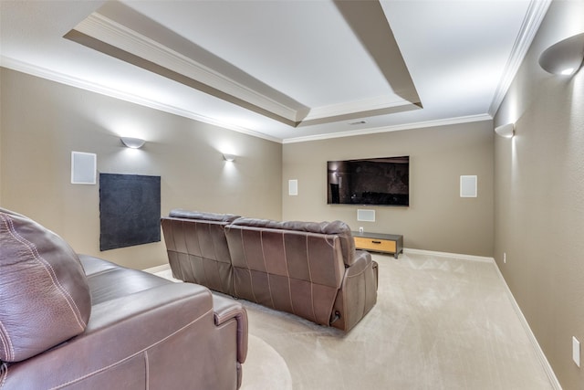 cinema room featuring a tray ceiling, ornamental molding, baseboards, and light carpet