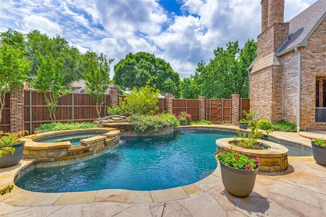 view of swimming pool featuring a patio, a fenced backyard, and a pool with connected hot tub
