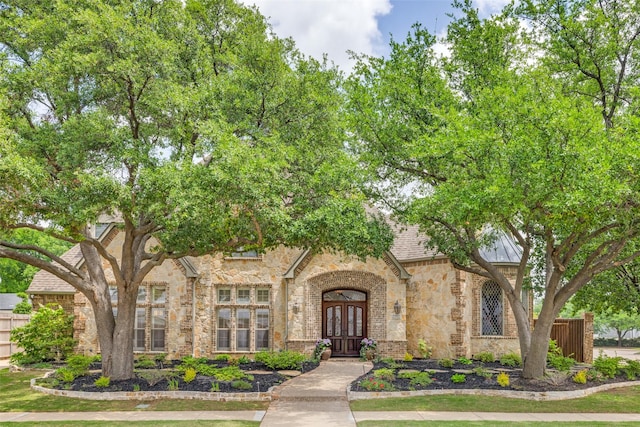 view of front of property with fence, brick siding, and stone siding
