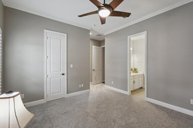 unfurnished bedroom featuring visible vents, crown molding, baseboards, ensuite bathroom, and light carpet