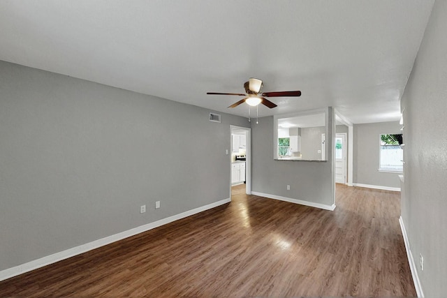 spare room featuring baseboards, a ceiling fan, wood finished floors, and visible vents