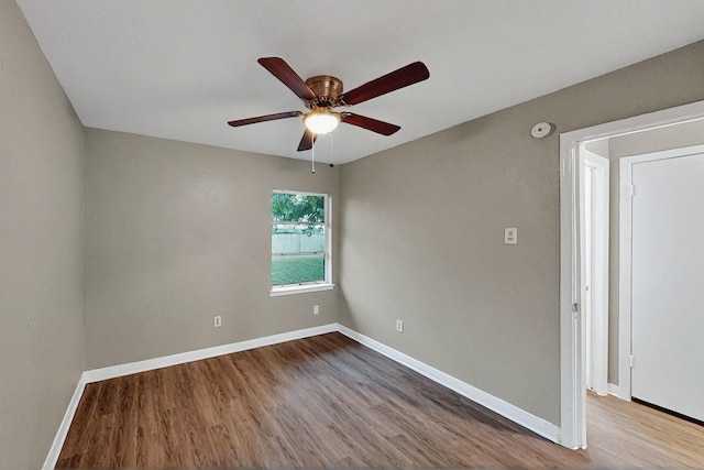 empty room featuring baseboards, ceiling fan, and wood finished floors