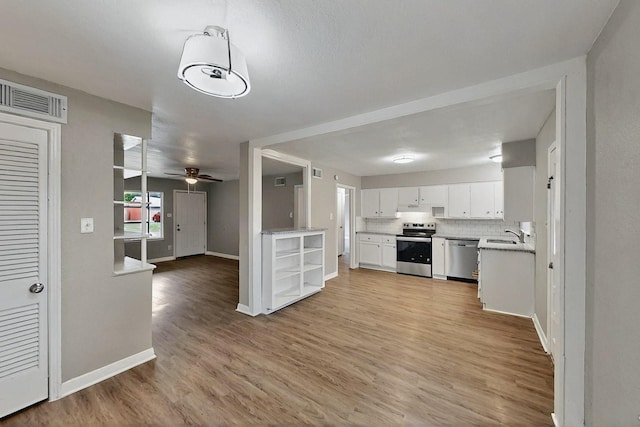 13439 Glenside Dr, Farmers Branch, TX 75234 - kitchen featuring visible vents, baseboards, white cabinets, stainless steel appliances, and light wood-style flooring