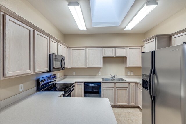 kitchen with a sink, light brown cabinetry, black appliances, and light countertops