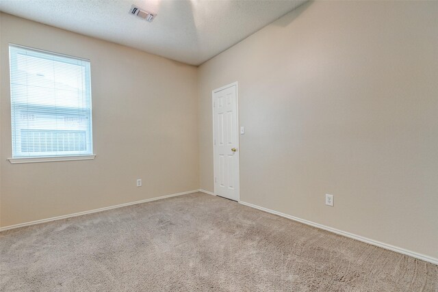 empty room featuring visible vents, carpet, and baseboards