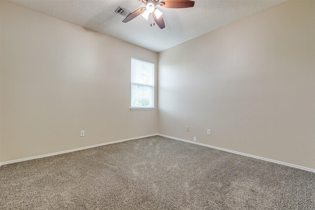 empty room featuring a ceiling fan, a textured ceiling, visible vents, baseboards, and carpet