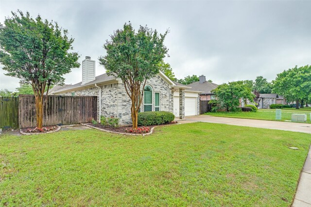 view of front of house with fence, an attached garage, driveway, and a front yard