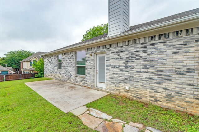 rear view of house featuring a patio, a lawn, fence, and a chimney