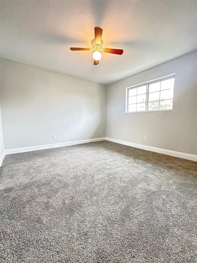 empty room with baseboards, a textured ceiling, carpet, and a ceiling fan