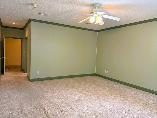 empty room with a ceiling fan, visible vents, ornamental molding, and carpet