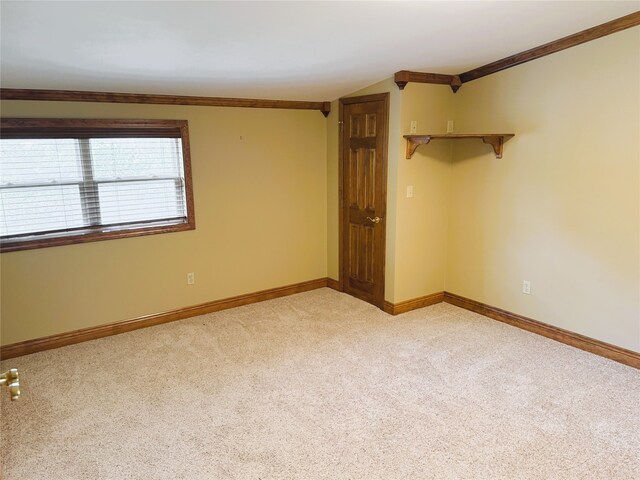 spare room with light colored carpet, baseboards, and crown molding