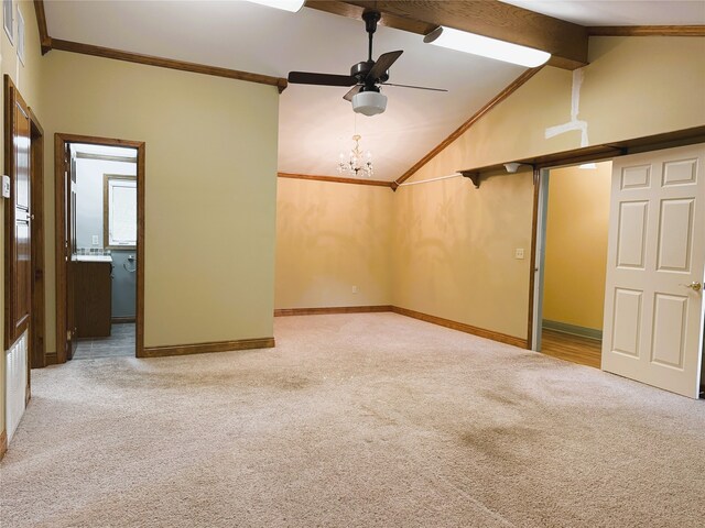 carpeted empty room with baseboards, vaulted ceiling with beams, ornamental molding, and ceiling fan with notable chandelier