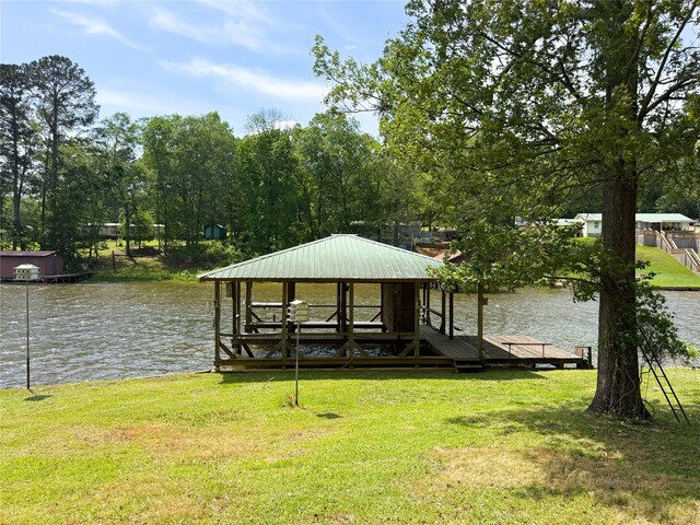 view of dock featuring a lawn, a water view, and boat lift