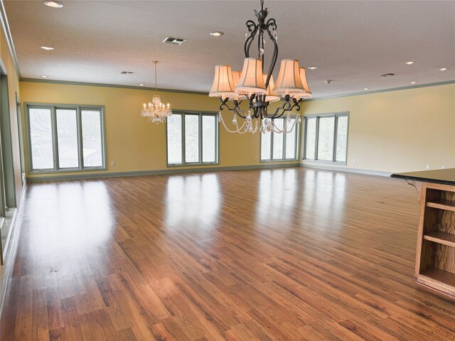 interior space with visible vents, baseboards, wood finished floors, and a notable chandelier
