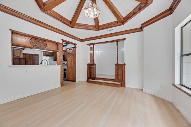 unfurnished living room featuring an inviting chandelier, plenty of natural light, light wood-type flooring, and a sink